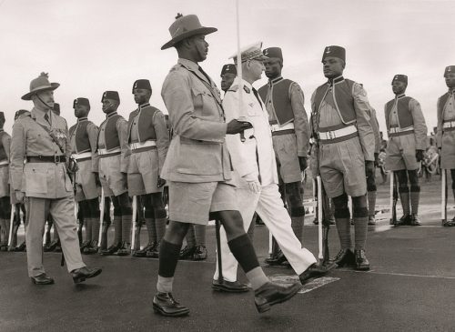 Colonial military officer inspecting soldiers of the West African Frontier Force during a ceremonial parade.